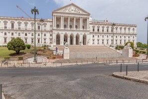 Un grand bâtiment de style classique, doté d’une entrée imposante, de nombreuses colonnes et d’une statue.