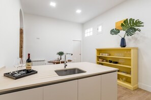 Eine moderne Küche mit einer zentralen Kochinsel, einer integrierten Spüle und einem gelben Schrank.