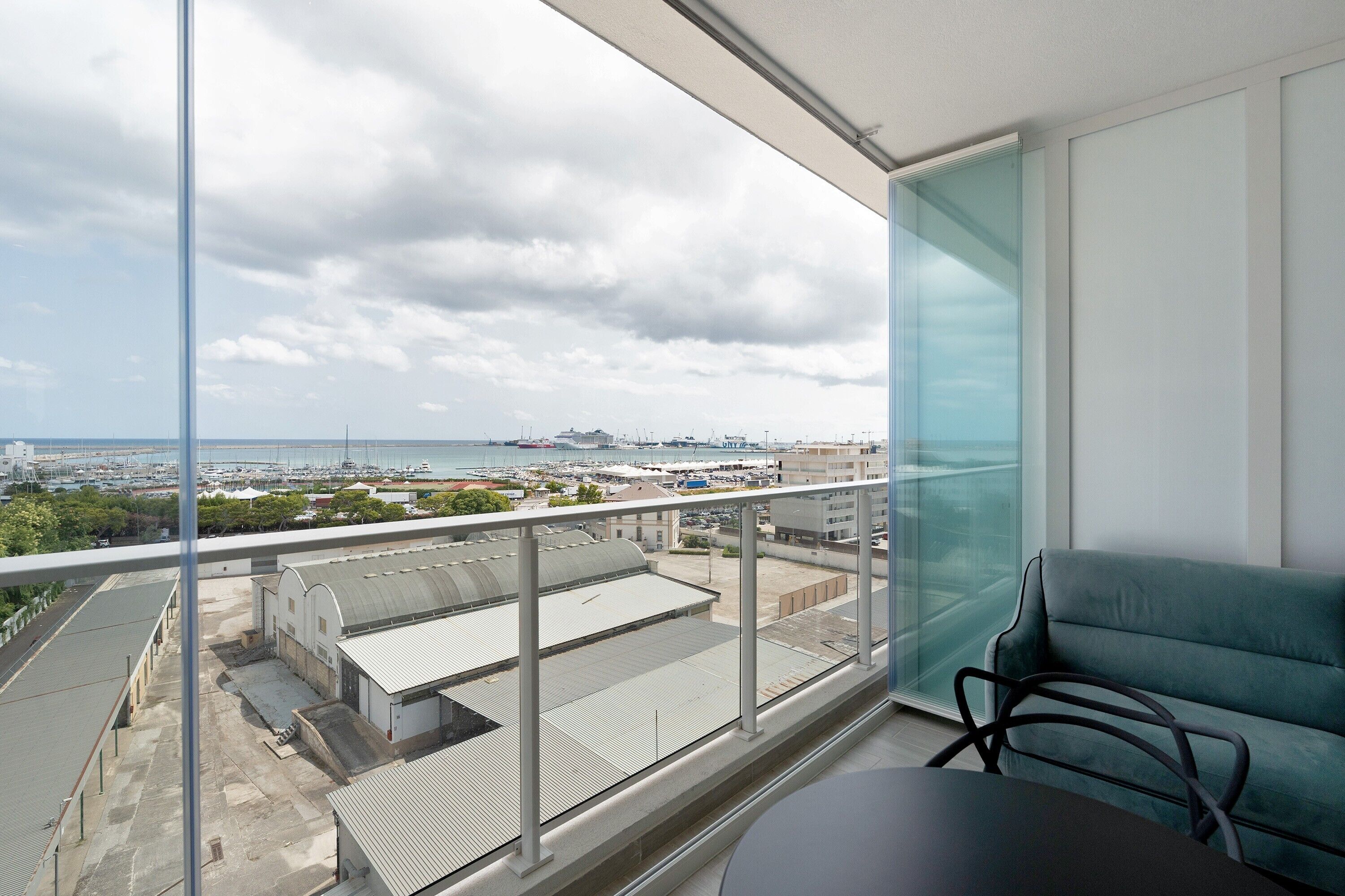 Ein Balkon mit Blick auf einen Yachthafen und die Skyline der Stadt.