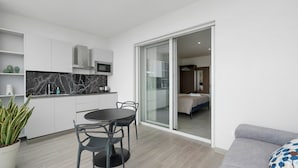 A modern apartment with a kitchen, dining area, and a bedroom with a sliding glass door. - Apartment 'U Gnore - Polpo Room' with Sea View, Wi-Fi and Air Conditioning (Bari)
