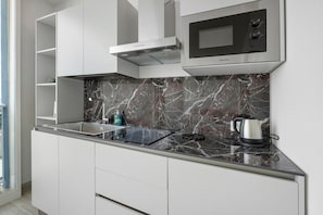 A modern kitchen with a stainless steel sink, a microwave, and a kettle on the counter. - Apartment 'U Gnore - Polpo Room' with Sea View, Wi-Fi and Air Conditioning (Bari)