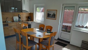 Een moderne keuken met een eethoek, inclusief een tafel, stoelen, een koffiezetapparaat en een raam met uitzicht.