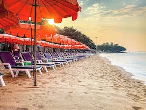 A beach with rows of sun loungers and orange umbrellas. - Pattaya Central Excellent 1 Bed Room Near Beach (Pattaya)