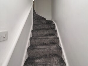 Eine Treppe mit Teppichstufen und weißen Wänden.