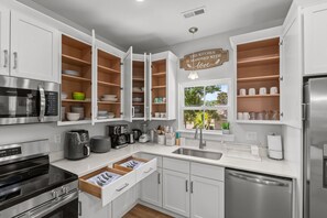 A modern kitchen with white cabinets, stainless steel appliances, and open shelving. - Beachfront Luxury Apartment w/ Free Parking & (Myrtle Beach)