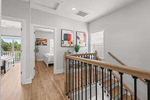 A modern interior with a staircase, wooden railing, and artwork on the walls. - Beachfront Luxury Apartment w/ Free Parking & (Myrtle Beach)