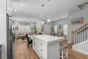 A modern kitchen with a large island, white cabinetry, and pendant lighting. - Beachfront Luxury Apartment w/ Free Parking & (Myrtle Beach)