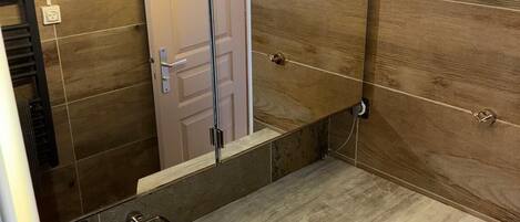 A compact bathroom with a sink, mirror, and washing machine.