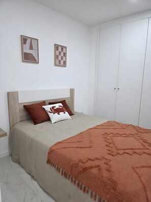 A bedroom with a bed, a wardrobe, and two framed artworks on the wall. - Casa da Lota: House with Large Terrace, Sea and Lota View (Vieira de Leiria)