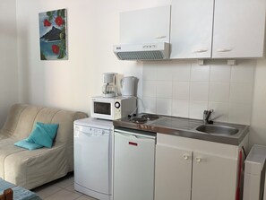 Une petite cuisine équipée d’un four à micro-ondes, d’une machine à café et d’un petit réfrigérateur.