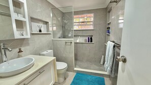 Een douche, handdoeken, zeep, shampoo