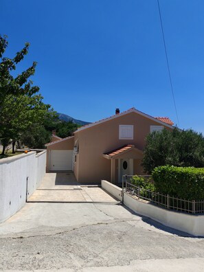 A residential building with a garage, a driveway, and a mountain in the background. - Exclusive Retreat Villa Split - Heated pool with Hydrolysis system (no chlorine) (Solin)