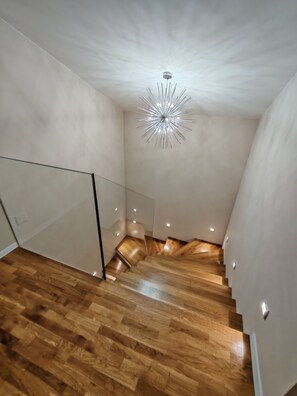 A modern interior with a wooden staircase, a glass partition, and a unique ceiling light fixture. - Exclusive Retreat Villa Split - Heated pool with Hydrolysis system (no chlorine) (Solin)