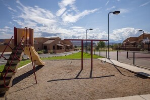 A playground with a slide, swings, and a climbing structure.