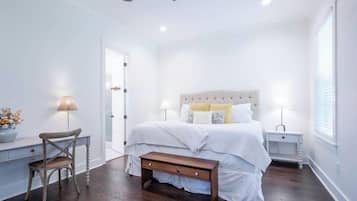 A bedroom with a bed, bedside tables, a chair, and a bench.
