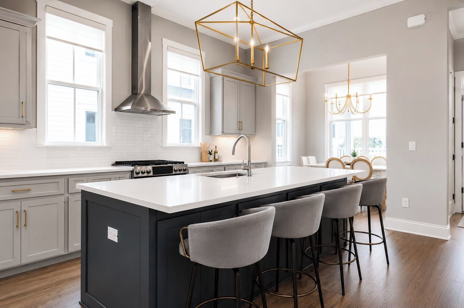 A modern kitchen with a large island, bar stools, and pendant lighting.