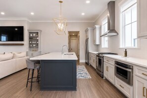 A modern kitchen with a central island, stainless steel appliances, and a built-in oven. - The Social, 3mi to SQ + Pool by VelvetDitchVillas (Oxford)