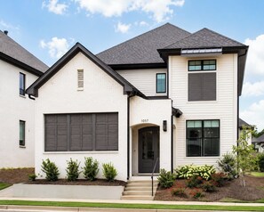 A two-story house with a garage, a front door, and a number '1057' on the door. - The Social, 3mi to SQ + Pool by VelvetDitchVillas (Oxford)