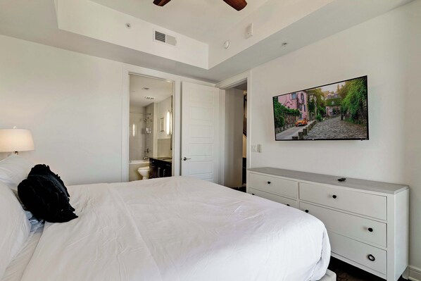 A bedroom with a bed, a dresser, a mirror, and a painting on the wall. - Luxury 3BR Penthouse |Skyline Views |Uptown Dallas (Dallas)
