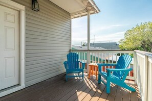 A covered porch with two blue Adirondack chairs and a small table. - Heated Pool-Fun Game Room -Close to Beach-Pet Friendly (Galveston)