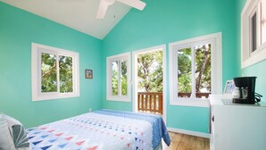 A bedroom with a bed, a desk, and a coffee maker.