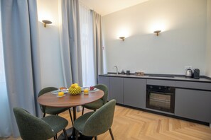 A modern kitchen with a dining table, chairs, and a built-in oven. - Luxury Boutique Apartment 4 in Palermo City Center, near the Central Station (Palermo)