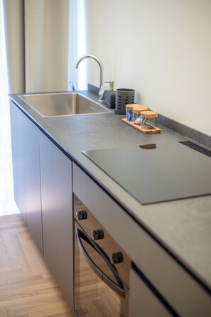 A modern kitchen with a stainless steel sink, a built-in oven, and a wooden countertop. - Luxury Boutique Apartment 4 in Palermo City Center, near the Central Station (Palermo)