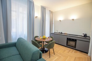 A modern kitchen with a dining area, featuring a round table, chairs, and a sofa. - Luxury Boutique Apartment 4 in Palermo City Center, near the Central Station (Palermo)