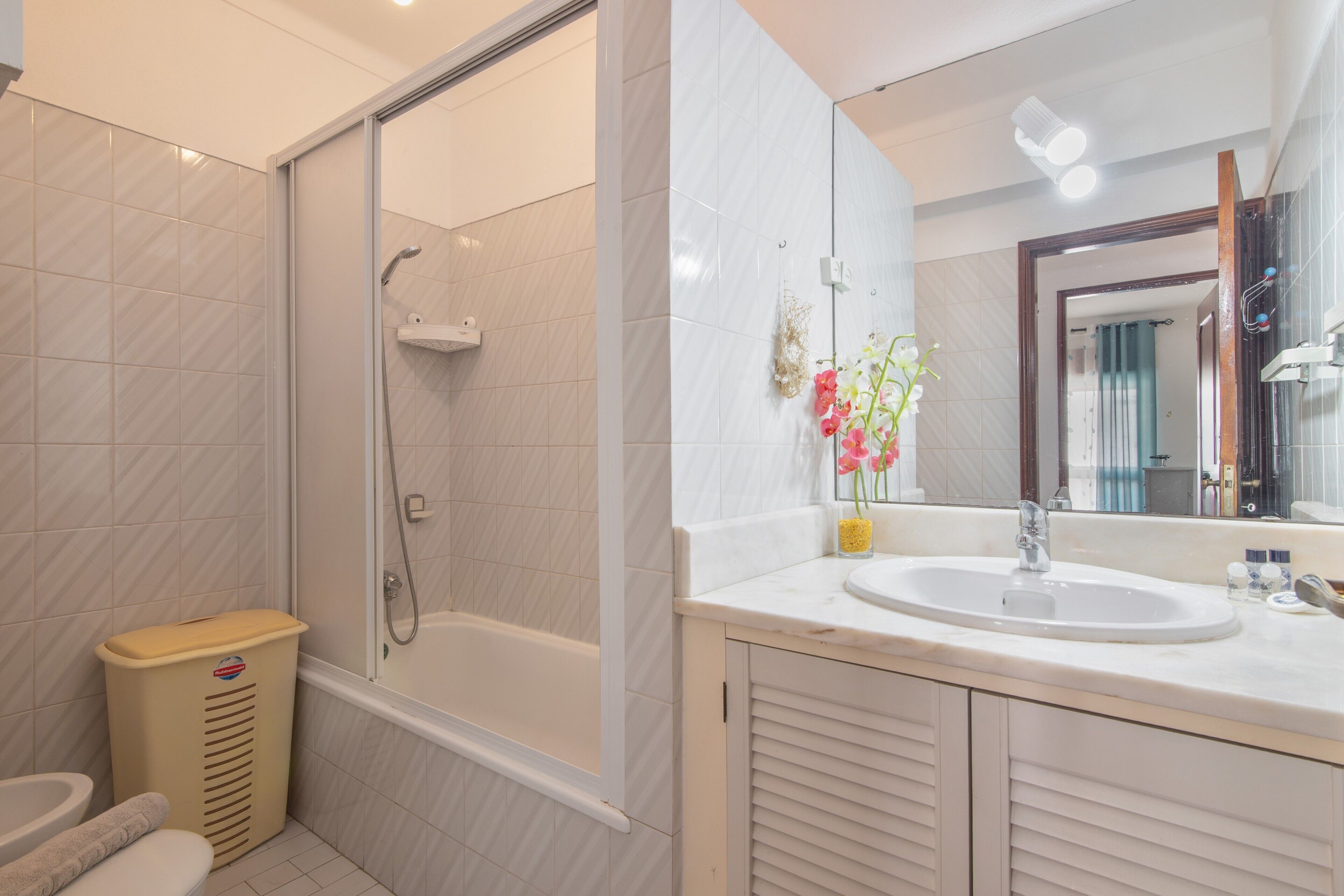 Et moderne badeværelse med bruser, toilet og håndvask.
