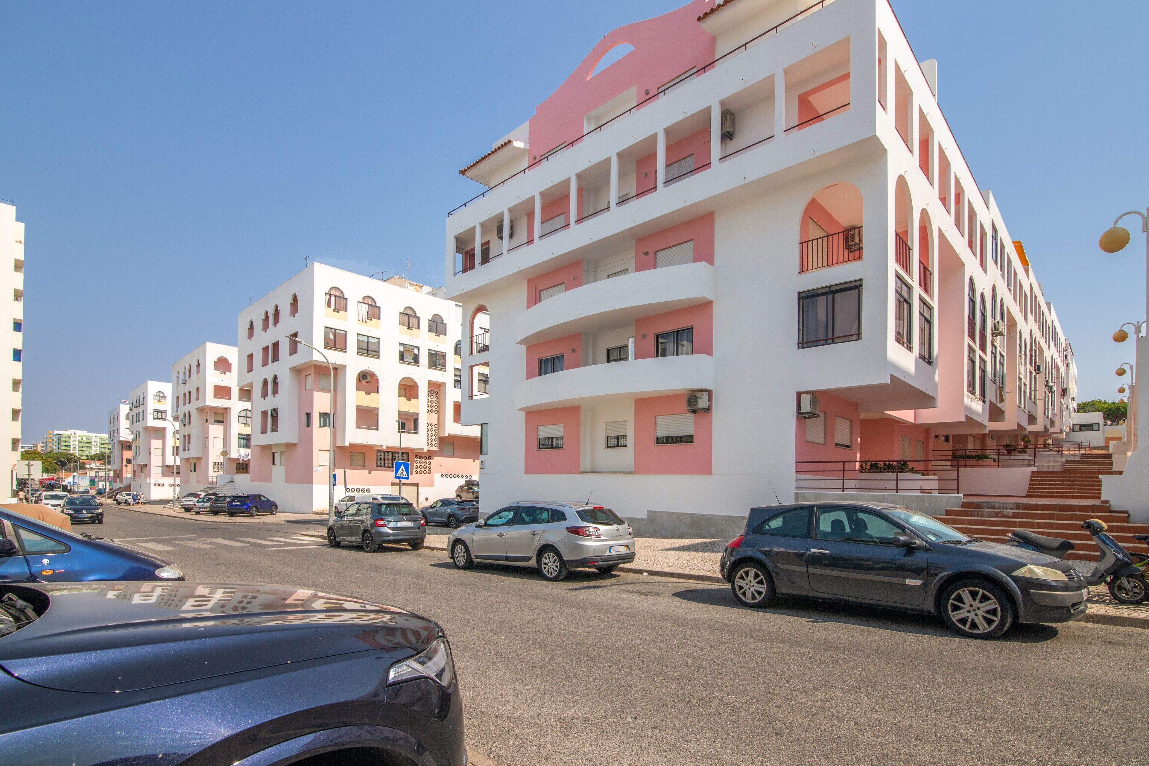 A multi-story residential building with balconies and a pedestrian staircase.