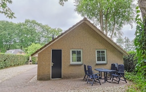 A small brick building with a door, two windows, and a table with chairs outside. - Luxury vacation home in Lunteren, in the Veluwe region (Lunteren)