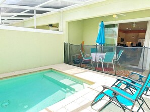A swimming pool with a glass enclosure, a table with chairs, and a blue umbrella. - TR17430PA - Affordable Disney - Townhome 3Bd 3Ba Sleeps 6 Pond view (Clermont)