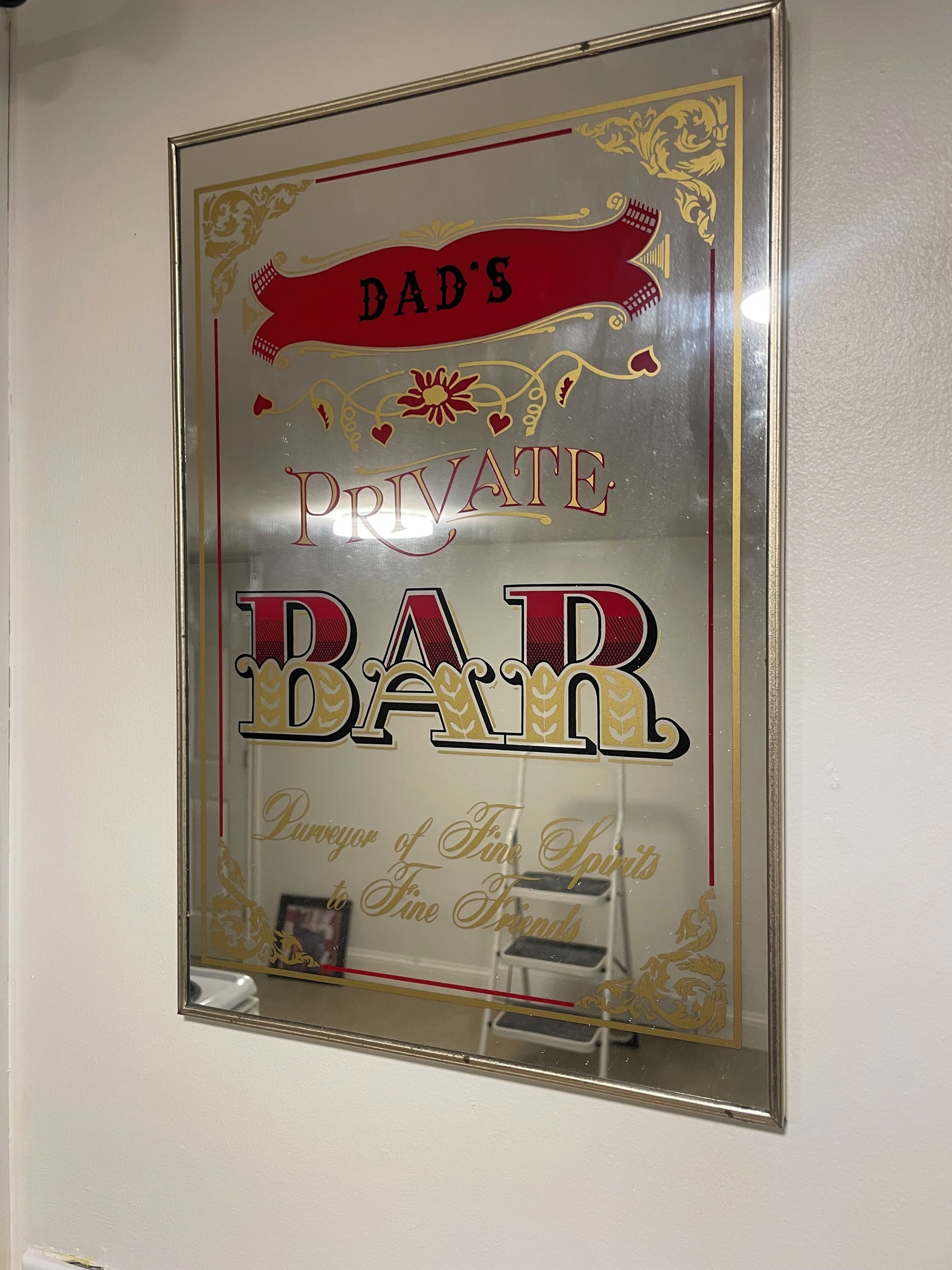 Un cartel enmarco con el texto 'BAR PRIVADO DE PAPÁ' y 'Amante de Licores Finos, Amigo Fiel'.