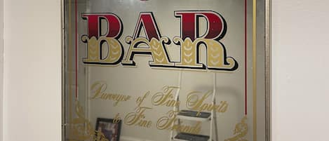 Un cartel enmarco con el texto 'BAR PRIVADO DE PAPÁ' y 'Amante de Licores Finos, Amigo Fiel'.