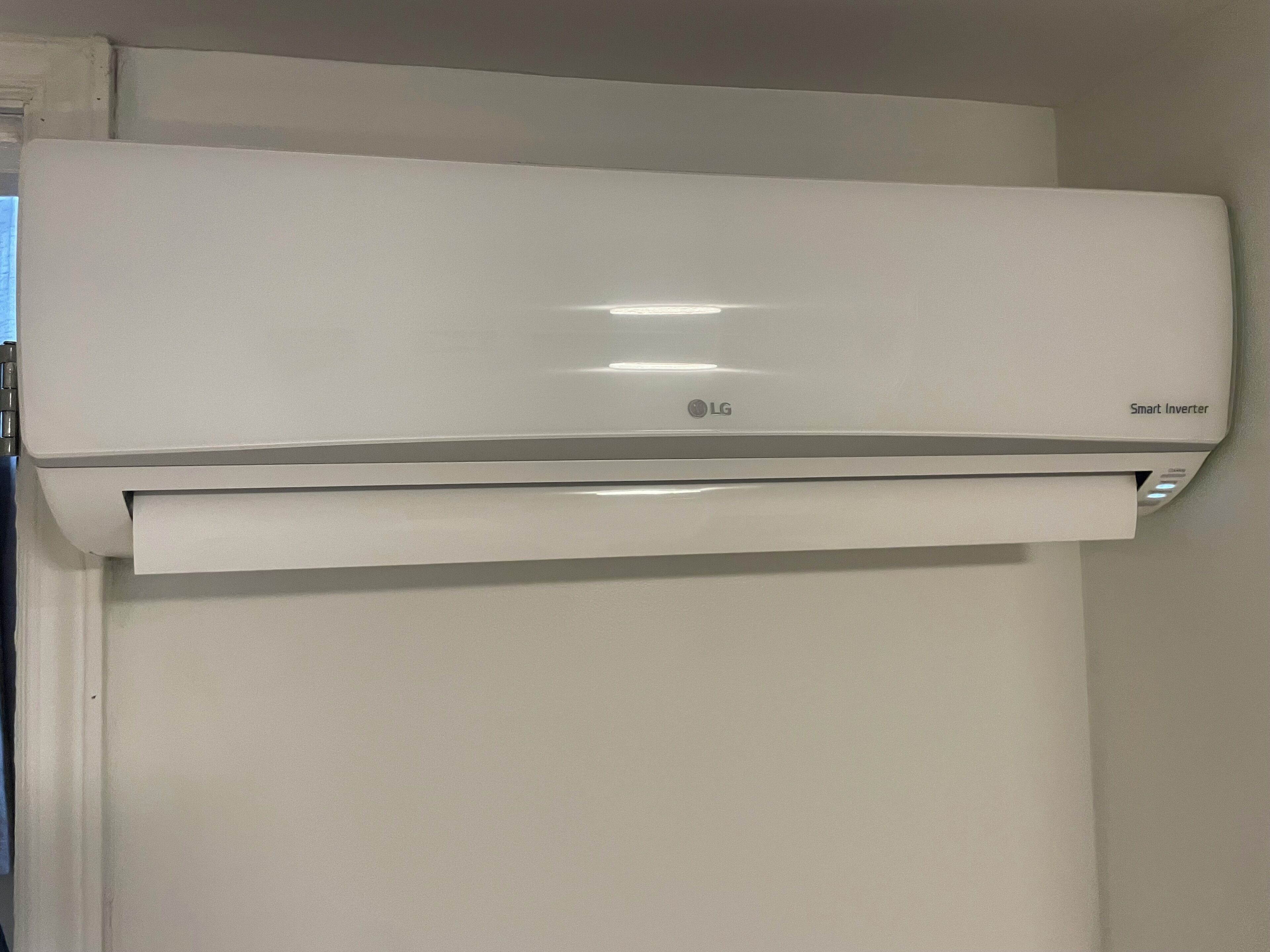 A white LG Smart Inverter air conditioner mounted on a wall.