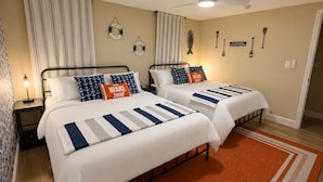 A hotel room with two beds, striped bedding, nautical-themed pillows, a wake zone sign, and a ceiling fan. - Waterfront, Gulf Access, Docks, Fishing, Games, Pool (Port Richey)