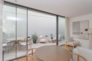 A modern interior with a glass wall, wooden furniture, and potted plants. - Liiiving in Porto - The Prestige Apartment E (Porto)