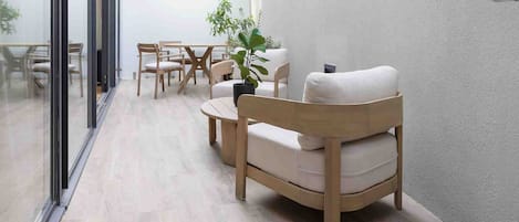 Un interior moderno con un largo pasillo, muebles de madera y una planta colgante.