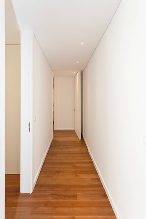 A corridor with wooden flooring and white walls. - Liiiving in Porto - The Prestige Apartment E (Porto)
