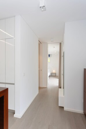 Ein modernes Interieur mit einem Flur, der zu einem Schlafzimmer, einem Badezimmer und einer Küchenzeile führt.