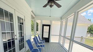 A covered porch with a ceiling fan, a black door, and blue chairs. - Secluded Harris Lake retreat. Nature, privacy, and Lake access to a private cove (New Hill)