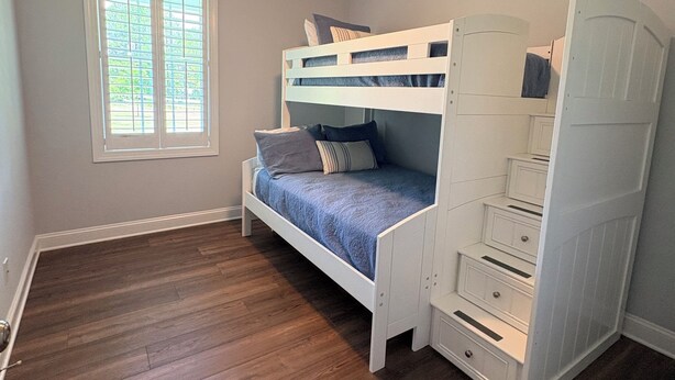 A bedroom with a bunk bed, a ceiling fan, and a window with blinds. - Secluded Harris Lake retreat. Nature, privacy, and Lake access to a private cove (New Hill)
