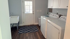 A laundry room with a washing machine, dryer, and a door leading to another room. - Secluded Harris Lake retreat. Nature, privacy, and Lake access to a private cove (New Hill)