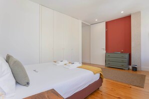 Une chambre à coucher avec un lit, une commode et une armoire.