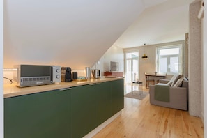 A modern kitchen with a built-in island, a coffee machine, and a toaster. - Liiiving in Porto - Vintage Terrace Apartment (Porto)