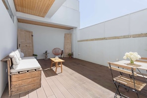 A patio with a bed, a small table, and a bench. - Liiiving in Porto - Vintage Terrace Apartment (Porto)