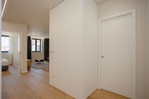 Una habitación con cama, una mesita, una silla y una puerta.