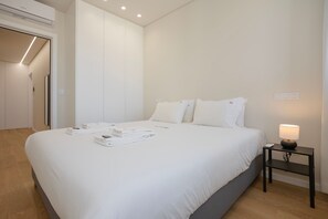 A bedroom with a bed, bedside table, and a lamp. - Liiiving in Matosinhos - Mercatus Apartment C (Matosinhos)