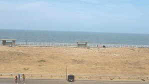 A beach with a sandy shore, a white railing, and a clear sky. - 1 Bedroom Beach View Apartment Sleeps 4 (Rhyl)