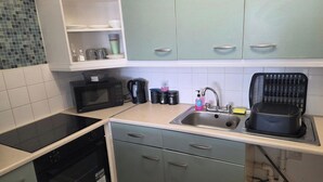 A kitchen with a microwave, kettle, toaster, and sink. - 1 Bedroom Beach View Apartment Sleeps 4 (Rhyl)